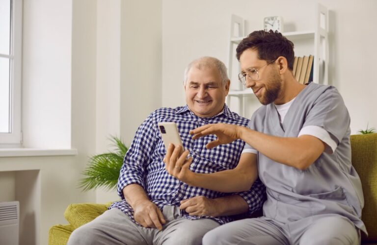 Caregiver showing an older adult his phone