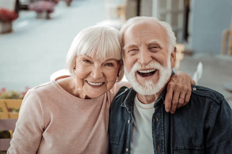 Couple of older adults laughing together.