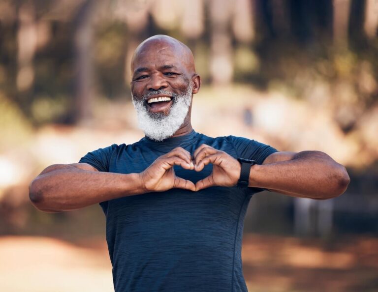 Happy older adult making a heart sign with his hands